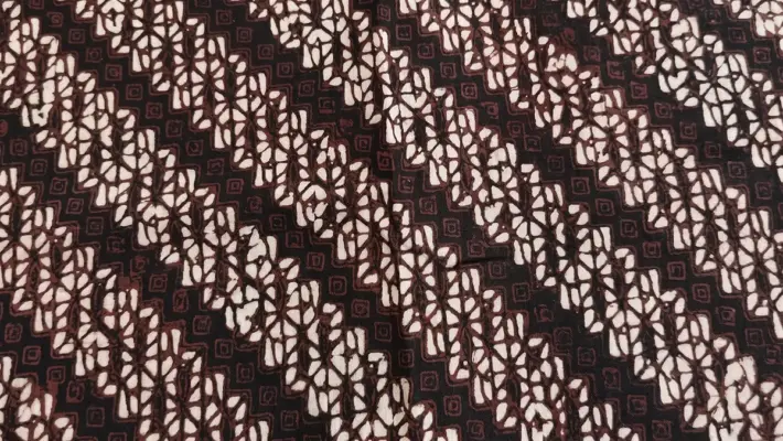 Authentic Jogja Parang Kusumo batik fabric featuring high-contrast white diagonal waves, dark brown geometric isen-isen veins, and subtle mlinjon diamonds on a deep black cotton background