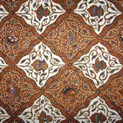 Close-up of authentic Sido Asih batik fabric showing repeating brown rhombus geometric patterns filled with traditional floral motifs. History of Batik