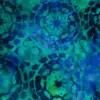 Repeating hand-stamped mandala floral pattern on deep ocean blue and emerald green 100% cotton batik fabric for quilting and apparel.