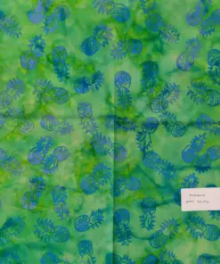 Vibrant green and tosca tropical batik fabric featuring contrasting blue pineapple stamped motifs scattered across a bright, energetic background.