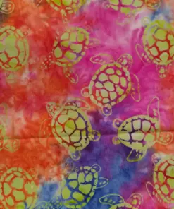 Vibrant sunset-colored batik fabric blending pink, orange, and blue with lime green sea turtle Hawaiian batik fabric for tropical projects.