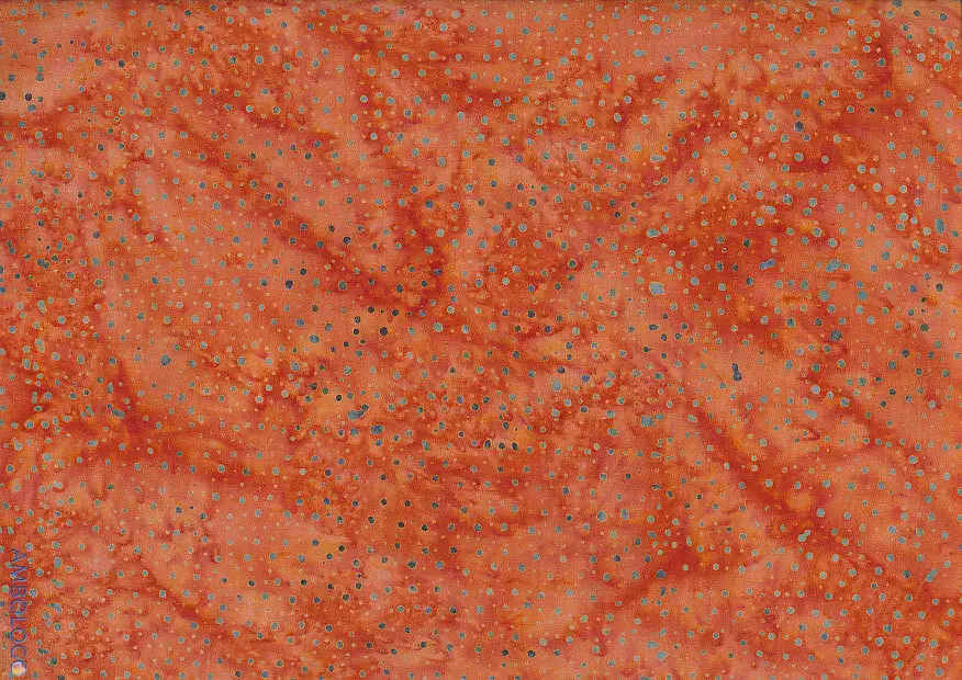 Vibrant tenne orange dotted batik fabric featuring a warm, rusty tawny hue with intricate dark blue speckles on 100% cotton, perfect for autumnal crafts.