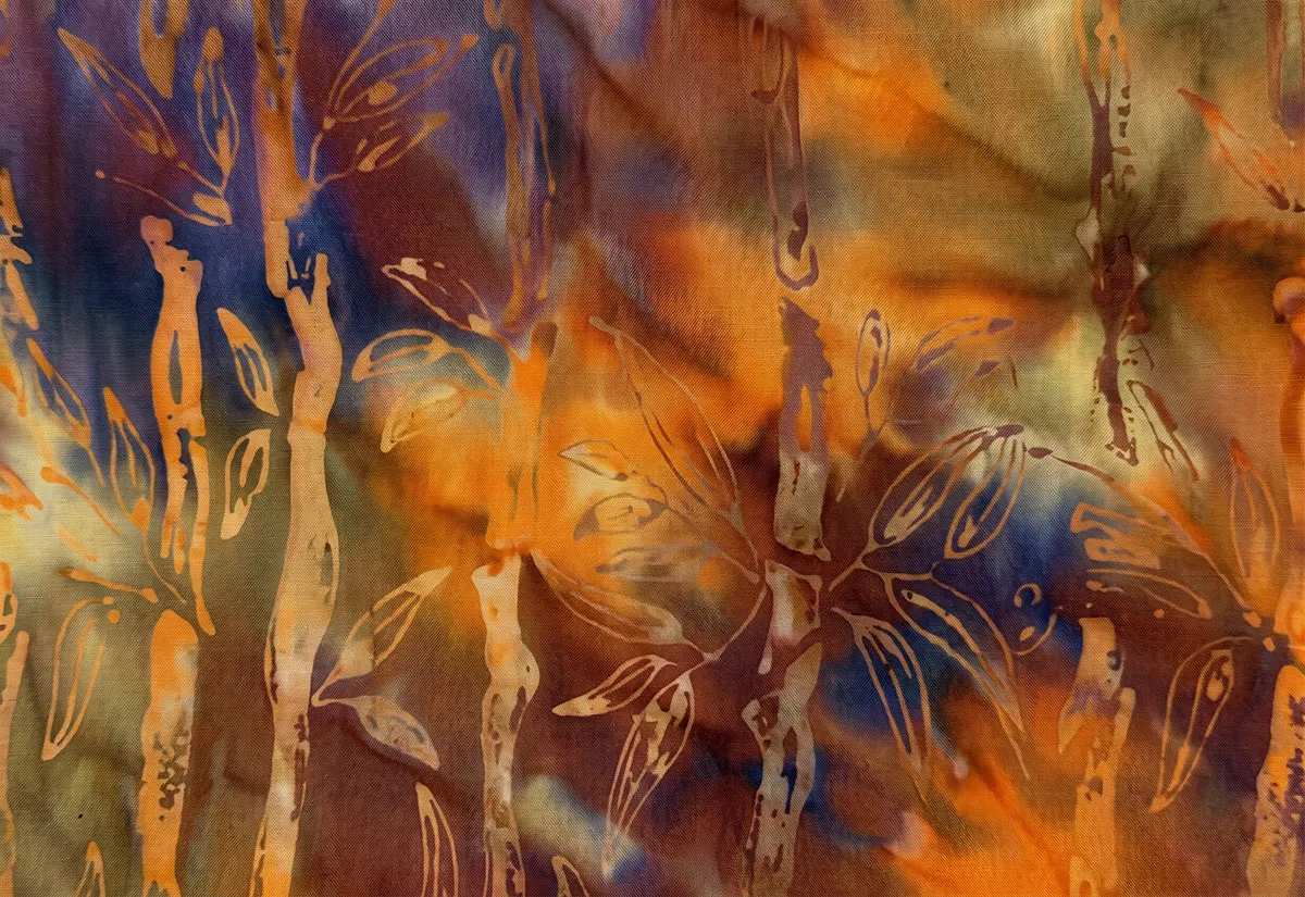 Monochromatic warm red-orange batik fabric with bold golden-yellow bamboo patterns.
