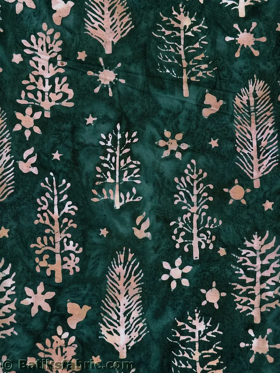 Evergreen woodland Christmas batik fabric showcasing peach-colored spruce trees, doves, and snow stars on a dark green background.