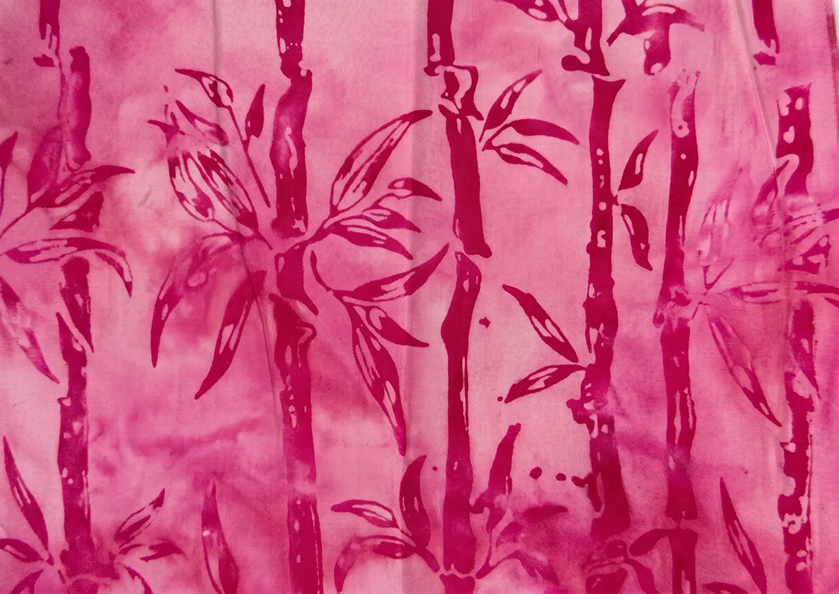 Soft pink gradient batik fabric featuring bold fuchsia and magenta bamboo stalk patterns.