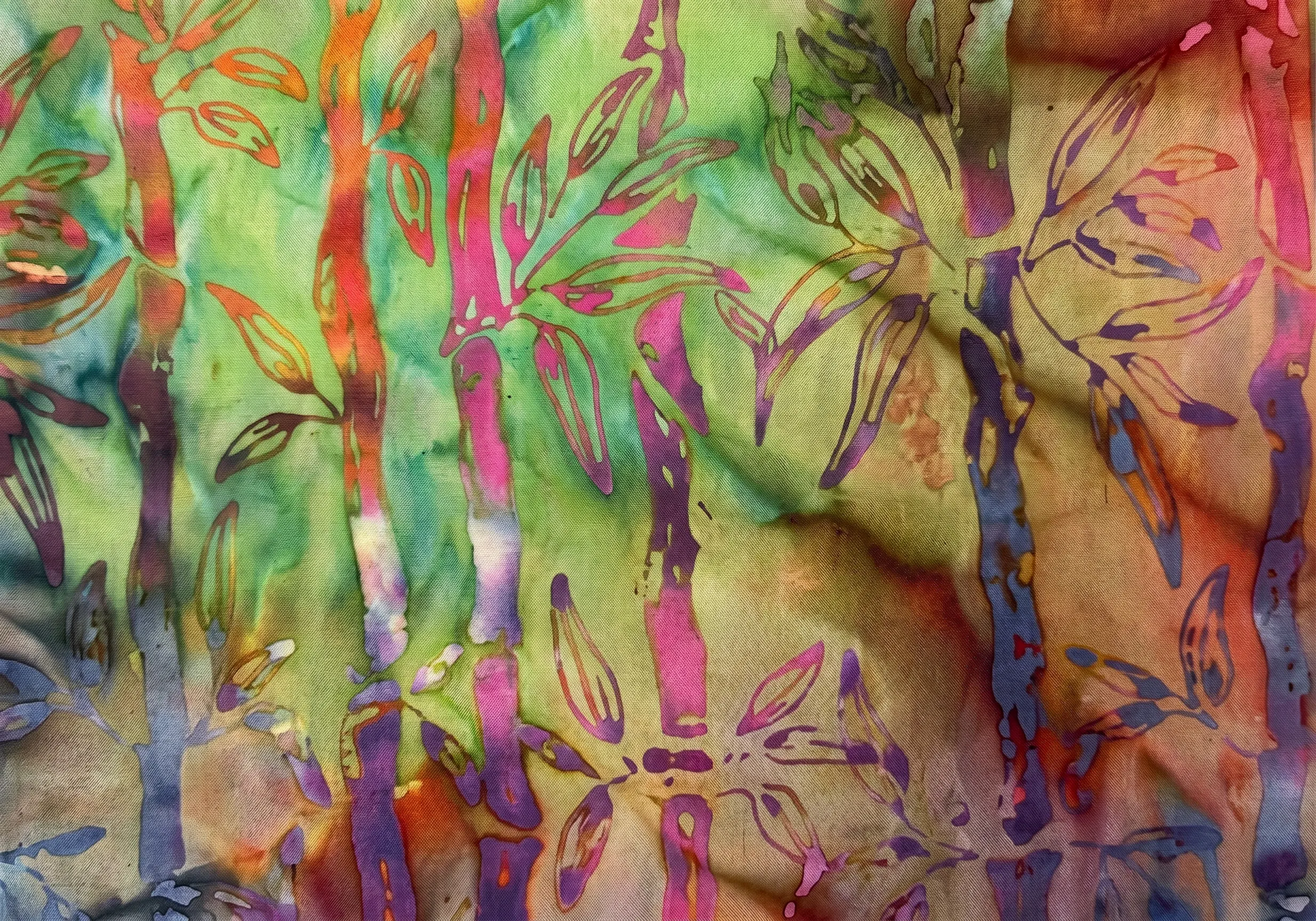 Vibrant rainbow multi-color batik fabric with intense pink and purple bamboo patterns.