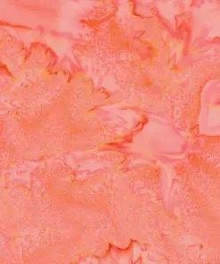 Close-up texture of Sweet Georgia peach tie-dye batik fabric showing mottled coral pink, warm salmon, and golden-yellow watercolor veins on 100% combed cotton.