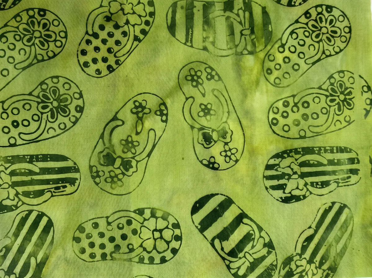Bright lime green hand-stamped sandal motif 100% cotton batik quilting fabric. Title: Bright Lime Green Sandal Motif Batik Cotton Fabric