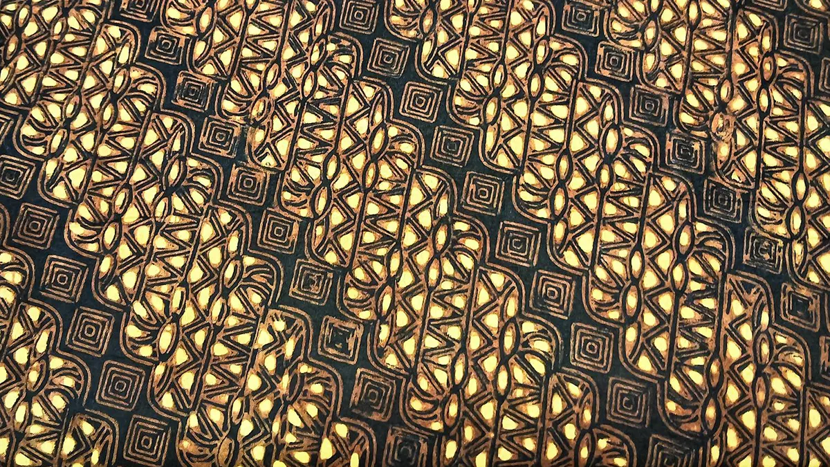 Authentic Solo Parang Kusumo batik fabric displaying warm golden-yellow sogan brown floral-contoured waves, zig-zag internal detailing, and concentric mlinjon diamond borders on a black background